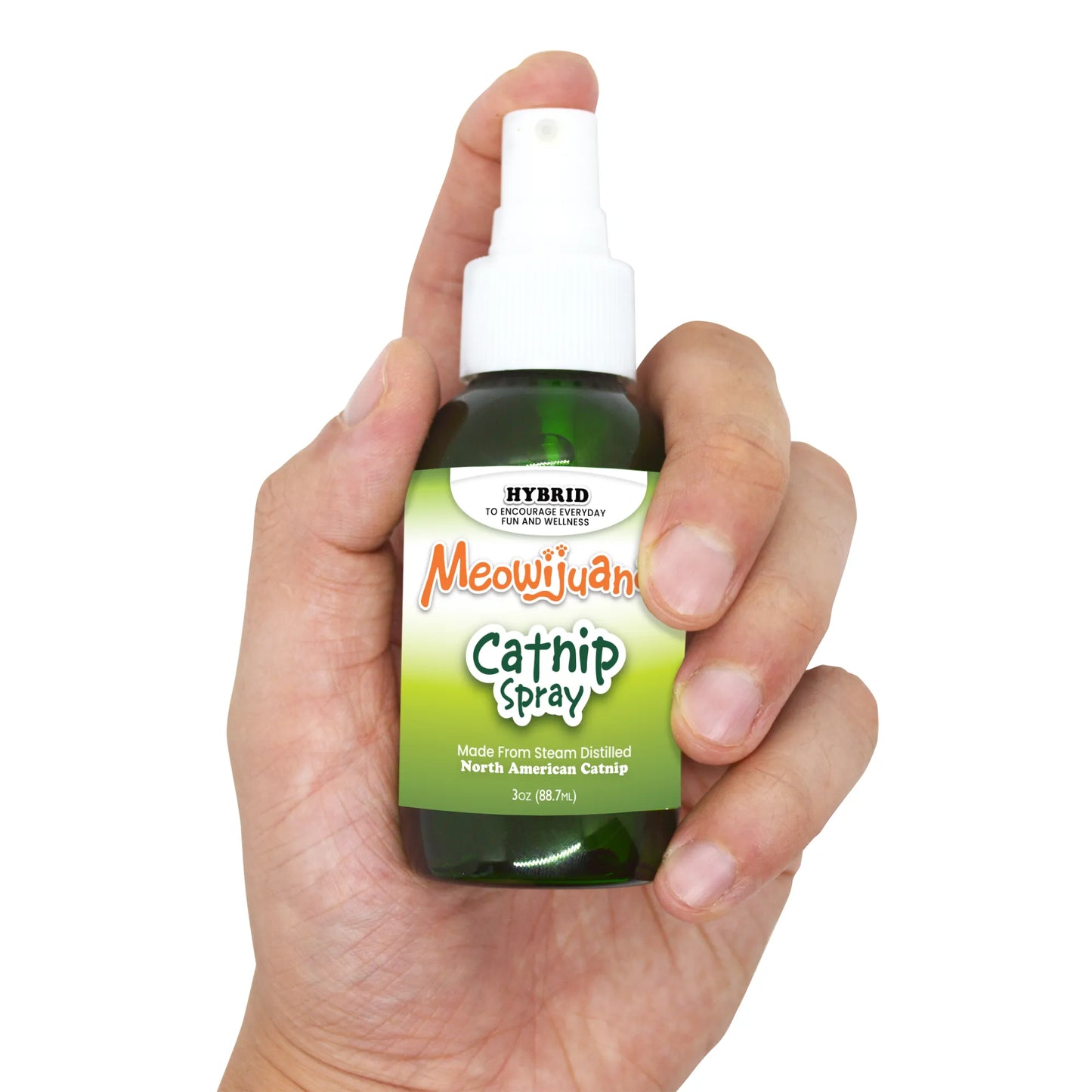 Hand holding a green bottle of Meowijuana Catnip Spray with a white label detailing its contents and usage.