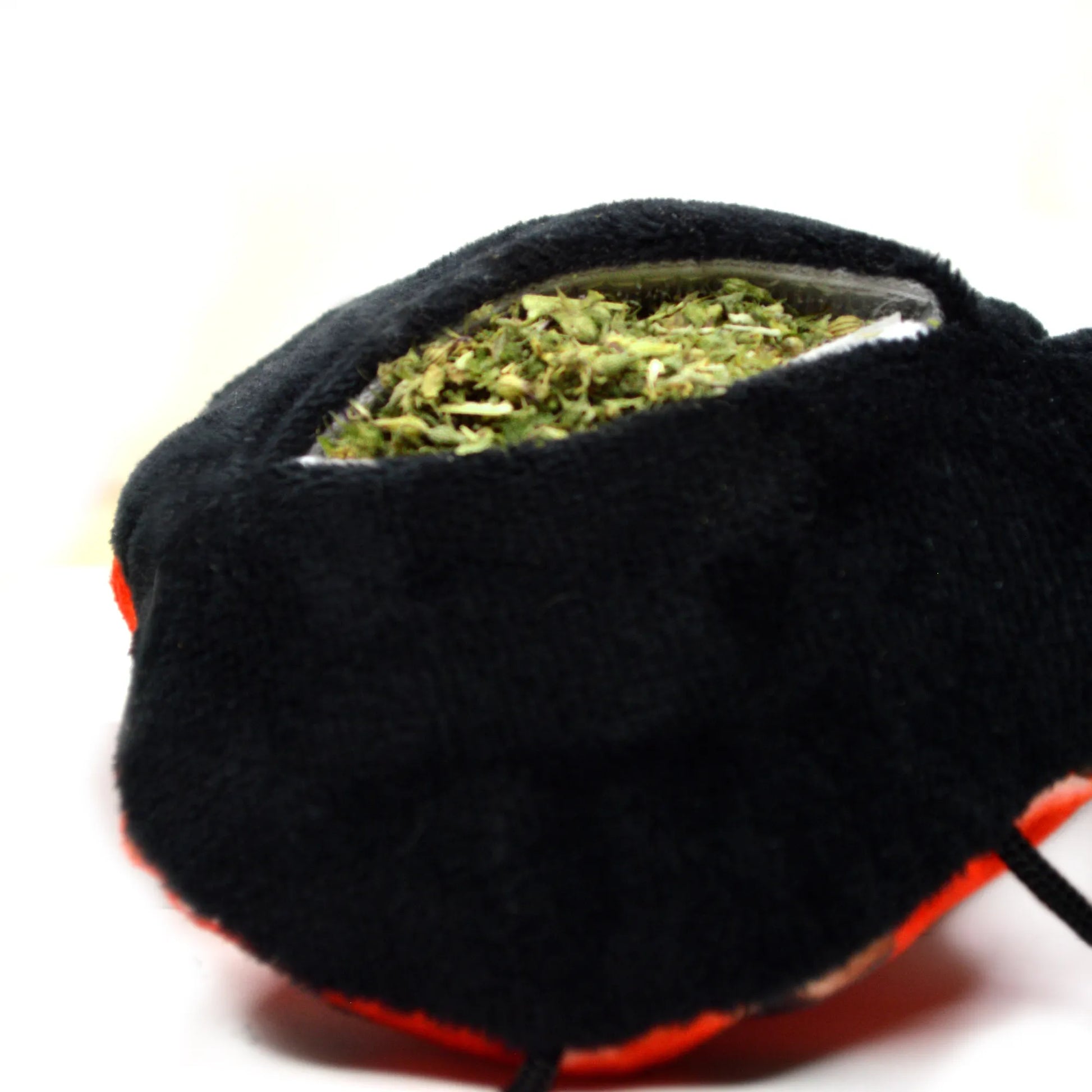 Side view of the ladybug toy showing an open refillable pocket filled with catnip.