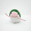 Front view of the pink shrimp roll toy with a smiling face and green band.