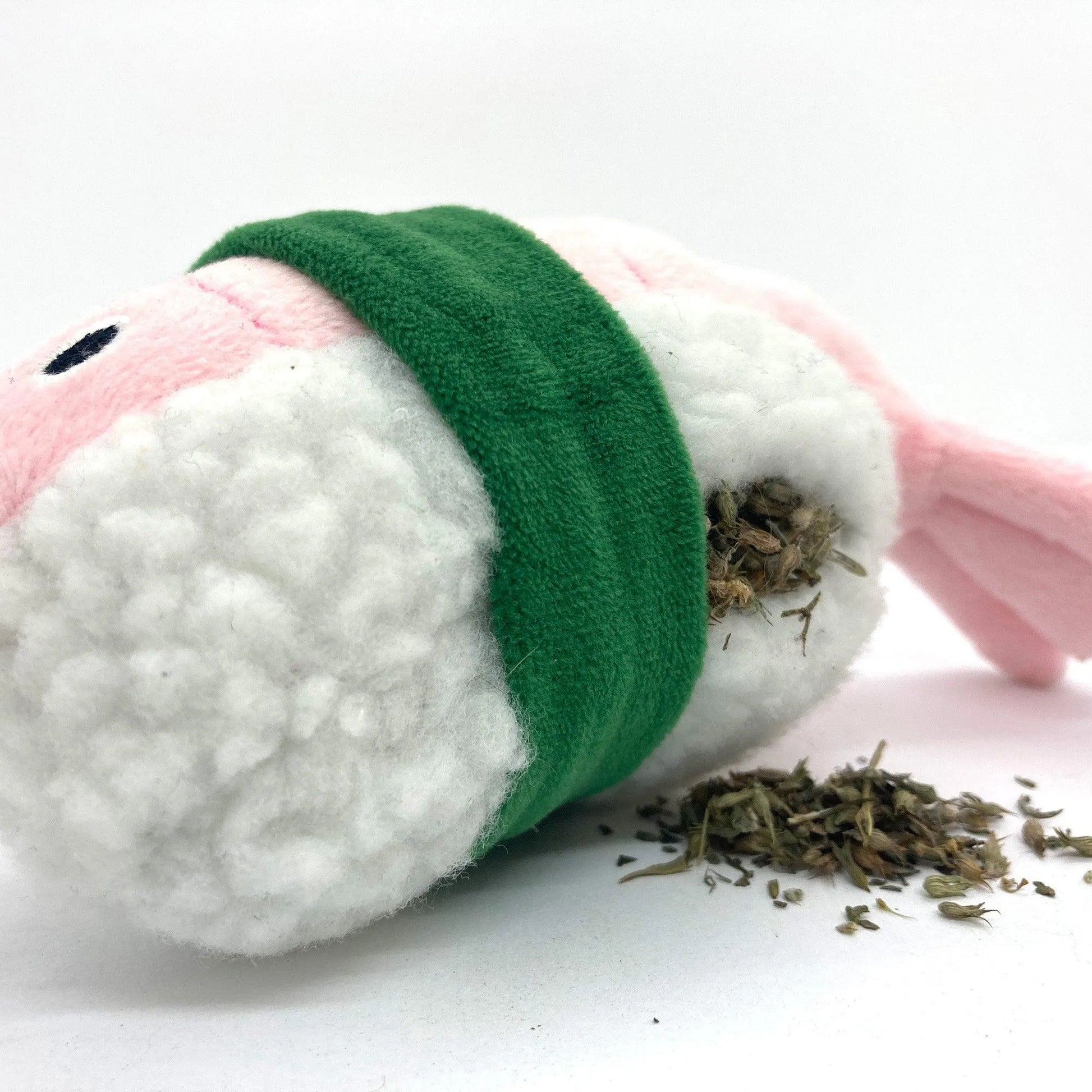 Close-up of the shrimp roll toy with catnip inside, spilling from the refillable pocket.